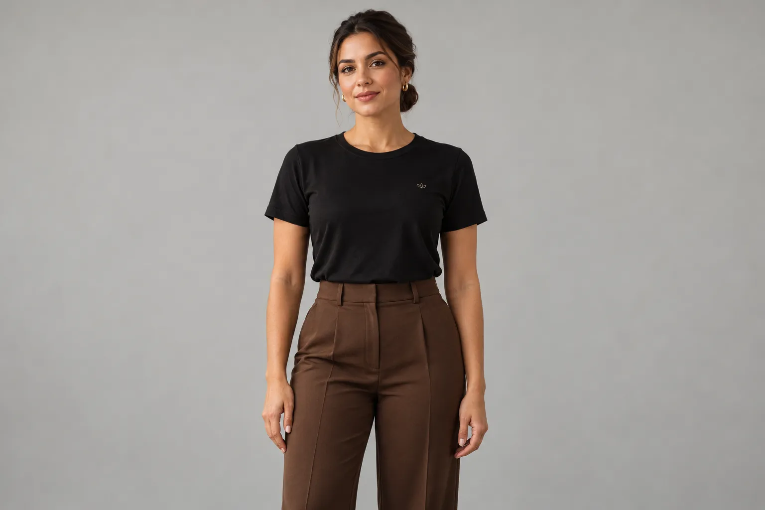 Mulher com camiseta preta e calça social marrom